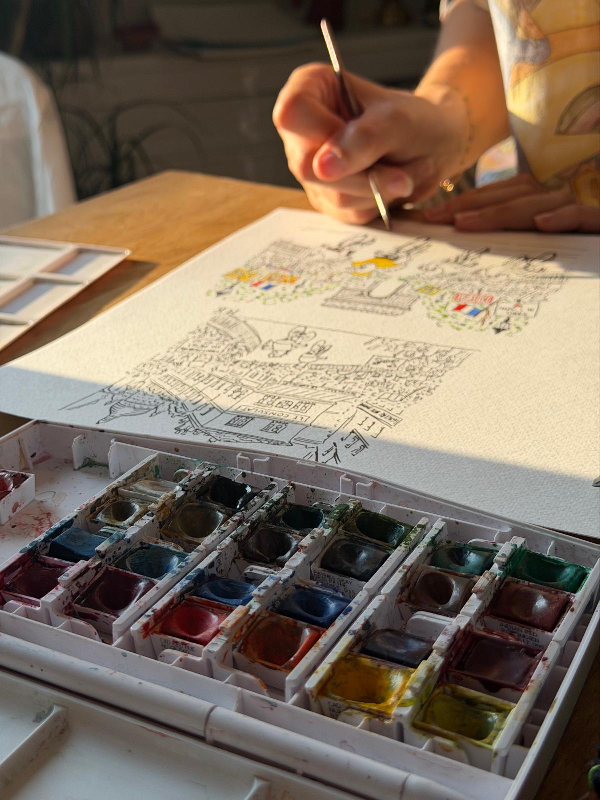 Marine peignant une illustration à l’aquarelle, sa palette au premier plan